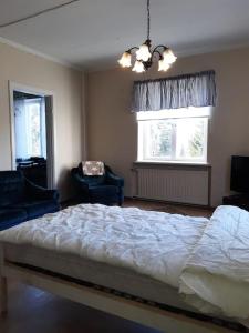 a bedroom with a large bed and two windows at Willa Witsari 35m2 asunto in Kokkola