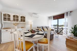 een keuken en een woonkamer met een tafel en stoelen bij Dreamalvor in Alvor