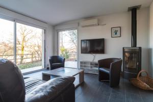 uma sala de estar com um sofá e uma lareira em Le Fusain - Maison climatisée pour 6 em Pont-Aven