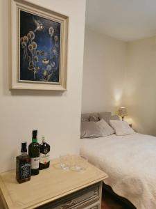a bedroom with a bed and a table with bottles of wine at Angels' Whisper - Studio City Center in Braşov