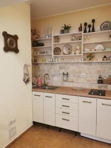 a kitchen with white cabinets and a sink and shelves at Angels' Whisper - Studio City Center in Braşov