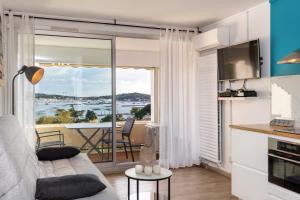 a living room with a couch and a view of the water at Studio avec vue mer et terrasse in La Seyne-sur-Mer
