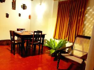 uma sala de jantar com mesa e cadeiras e uma planta em Coco Garden Villas em Hikkaduwa