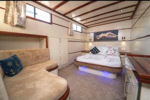 Habitación pequeña con cama y sofá en HKA NETA YACHTING en Göcek