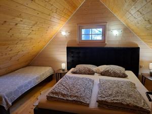 Schlafzimmer im Dachgeschoss mit 2 Betten und einem Fenster in der Unterkunft Black&White in Kołczewo