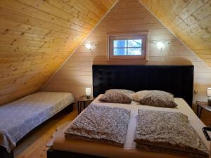 a attic bedroom with two beds and a window at Black&White in Kołczewo