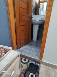 een badkamer met een wastafel en een deur met schoenen bij Sk Travellers Inn in Karachi
