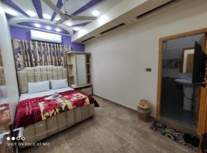 een slaapkamer met een bed en een wastafel in een kamer bij Sk Travellers Inn in Karachi