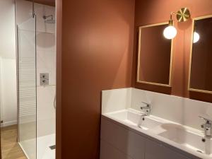ein Bad mit einem Waschbecken, einem Spiegel und einer Dusche in der Unterkunft Maison de 4 chambres avec jardin clos a Saint Cast le Guildo a 1 km de la plage in Saint-Cast-le-Guildo