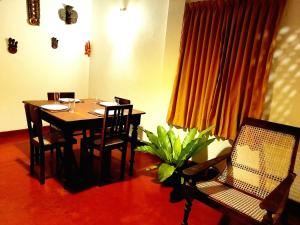 uma sala de jantar com mesa e cadeiras e uma planta em Coco Garden Villas em Hikkaduwa