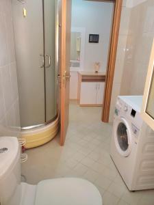 uma casa de banho com um WC e uma máquina de lavar roupa em Apartament 1+1 Plazh Durrës em Durrës