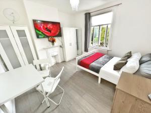 - une chambre avec un lit, une table et une fenêtre dans l'établissement Luxurious House near Excel- Air Conditioning, 9 Beds, 2 Baths, Garden, fast WiFi, à Londres