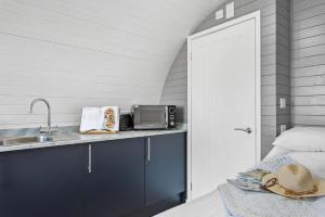 a kitchen with a sink and a microwave at Bramley, Apple Tree Glamping, Nr Wells in Wells
