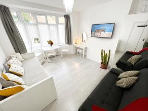 伦敦Luxurious House near Excel- Air Conditioning, 9 Beds, 2 Baths, Garden, fast WiFi的带沙发和桌子的客厅 更多33张照片