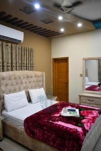 een slaapkamer met een bed met een tafel en een spiegel bij Sk Travellers Inn in Karachi