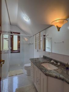 a bathroom with a sink and a toilet at Recanto do Pepê in Campos do Jordão