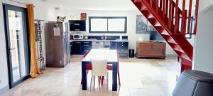 a kitchen with a table and chairs and a staircase at Gite les carriaux in Le Fied