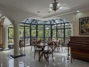 a dining room with tables and a piano at Recanto do Pepê in Campos do Jordão