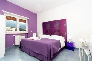 purpurowa sypialnia z łóżkiem z fioletową ścianą w obiekcie Guest House Emily Suites Sorrento w Sorrento