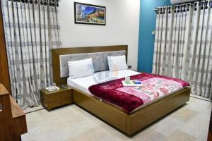 een slaapkamer met een bed met een rode deken bij Sk Travellers Inn in Karachi