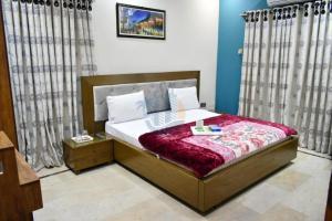 a bedroom with a bed with a red blanket at Sk Travellers Inn in Karachi +17 photos