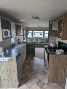 a kitchen with wooden cabinets and a counter top at Haven Holiday Home Littlesea Sleeps 6 in Weymouth