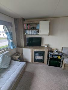 a small living room with a couch and a tv at Haven Holiday Home Littlesea Sleeps 6 in Weymouth