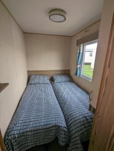 twee bedden in de hoek van een kleine kamer bij Haven Holiday Home Littlesea Sleeps 6 in Weymouth