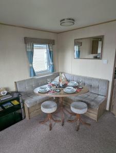 een woonkamer met een tafel en een bank bij Haven Holiday Home Littlesea Sleeps 6 in Weymouth