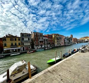 un gruppo di imbarcazioni ormeggiate su un fiume con edifici di Dream suites a Venezia