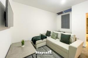 ein Wohnzimmer mit einem Sofa und einem TV in der Unterkunft Live In Style House In Desirable Location in Manchester