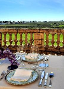 un tavolo con piatti e bicchieri da vino su un balcone di Chateau Tanesse de Tourny a Bayon