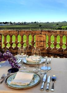 - une table avec des assiettes et des verres à vin sur un balcon dans l'établissement Chateau Tanesse de Tourny, à Bayon