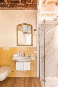 La salle de bains est pourvue d'un lavabo, de toilettes et d'un miroir. dans l'établissement Frattina Elegance Suite, à Rome