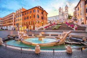 une fontaine au milieu d'une ville avec des bâtiments dans l'établissement Frattina Elegance Suite, à Rome