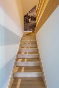 a staircase in a house with a painting on the wall at KoppenHerberg in Oudenaarde