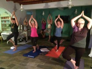 eine Gruppe von Leuten, die in einem Zimmer Yoga machen in der Unterkunft Hotel Porto Loutro on the Hill in Loutro