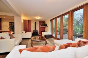 a living room with white furniture and large windows at Betws Y Coed Serviced Holiday Home in Betws-y-coed