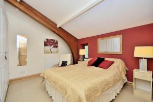 a bedroom with a large bed with red walls at Betws Y Coed Serviced Holiday Home in Betws-y-coed