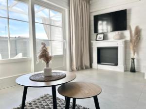 a white living room with a table and two chairs at BALTIC FAMILY Premium in Mielno