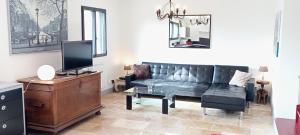 uma sala de estar com um sofá e uma televisão em Gite les carriaux em Le Fied