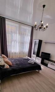 sypialnia z łóżkiem i żyrandolem w obiekcie Центр Апарт w mieście Tarnopol