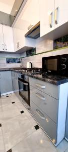 a large kitchen with stainless steel appliances and white cabinets at Центр Апарт in Ternopilʼ
