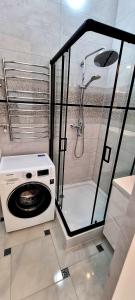 pralka w łazience z prysznicem w obiekcie Центр Апарт w mieście Tarnopol