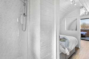 a white bathroom with a shower and a bed at Bramley, Apple Tree Glamping, Nr Wells in Wells