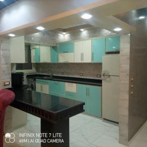 a large kitchen with blue and white cabinets at ستانلي اسكندريه in Alexandria