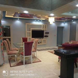 a living room with a table and chairs and a tv at ستانلي اسكندريه in Alexandria