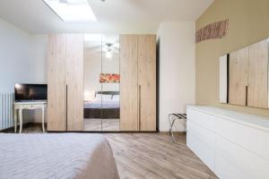 Schlafzimmer mit einem Bett, einem Schreibtisch und einem Spiegel in der Unterkunft House Under the Tower by Studio Vita in Bologna