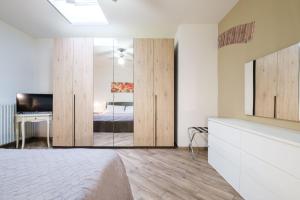 a bedroom with a bed and a desk and a mirror at House Under the Tower by Studio Vita in Bologna