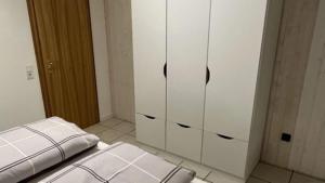 una habitación con armarios blancos y una cama en ella en Ferienwohnung Kessler, en Ommersheim